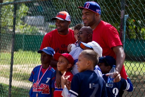 After a softball game they hosted for former baseball players, 35-year-old Gipsy Veras (left) and his brother Jose (right), who plays for the Chicago Cubs, meet young baseball players in Santo Domingo. Photo by Nickolai Hammar. 